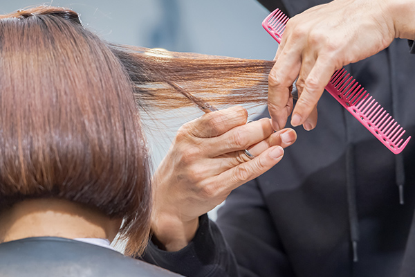 理容師にヘアセットをされる女性